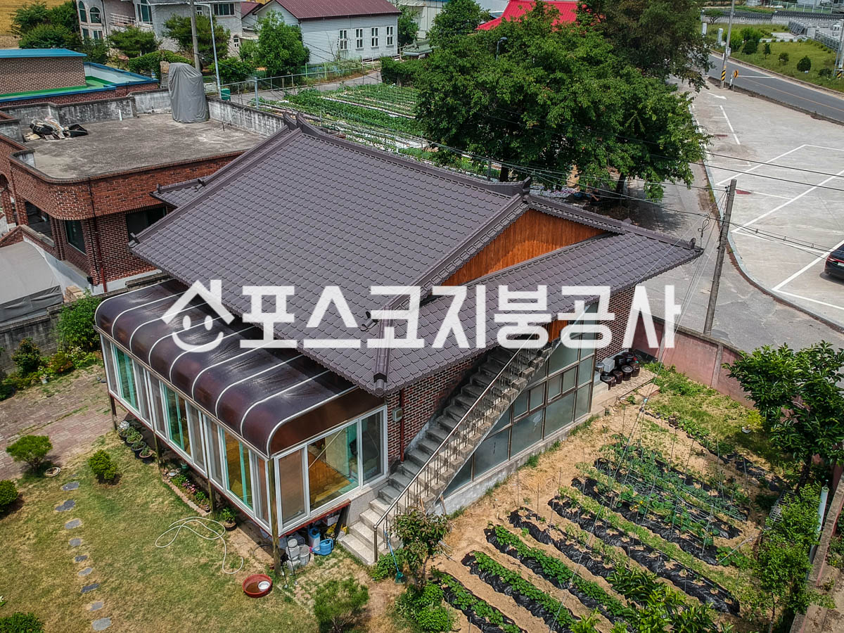 벽돌 주택 위에 갈색 기와 모양 칼라강판 지붕을 올린 모습